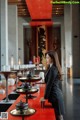 A woman in a business suit standing in front of a buffet.