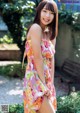 A woman in a pink dress posing for a picture.