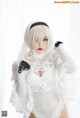 A woman in a white lingerie posing for a picture.